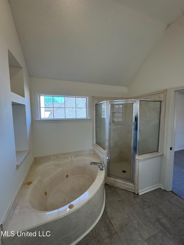 bathroom featuring a textured ceiling, separate shower and tub, vaulted ceiling, and tile patterned floors