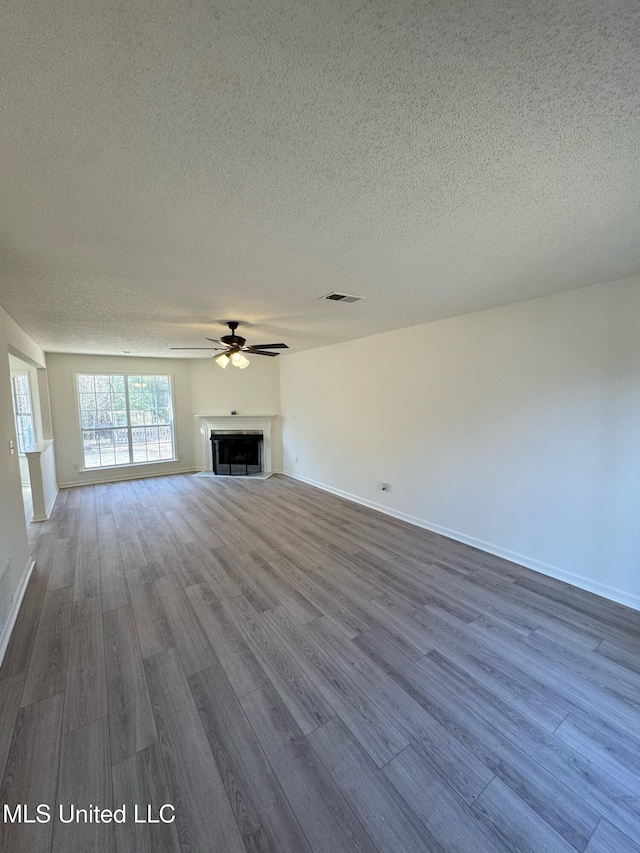 unfurnished living room featuring a textured ceiling, hardwood / wood-style flooring, and ceiling fan