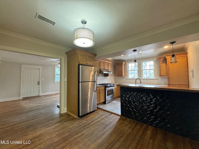 kitchen featuring hardwood / wood-style flooring, decorative light fixtures, appliances with stainless steel finishes, and ornamental molding