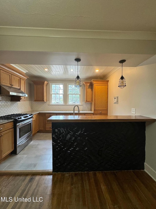 kitchen featuring crown molding, backsplash, stainless steel gas range, pendant lighting, and light hardwood / wood-style flooring