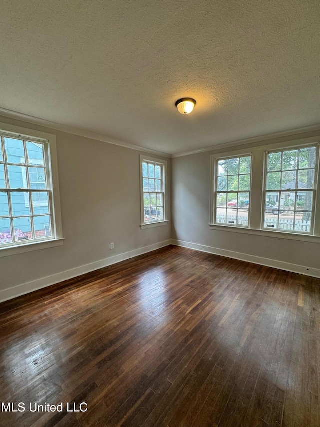 unfurnished room with plenty of natural light, a textured ceiling, crown molding, and dark hardwood / wood-style flooring