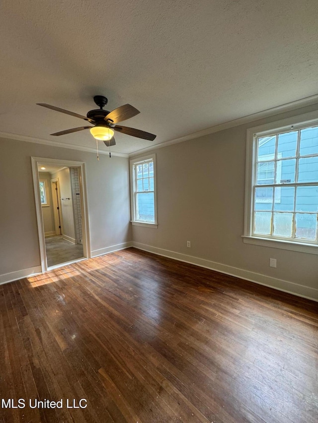 spare room featuring dark wood-type flooring, ceiling fan, a textured ceiling, and ornamental molding