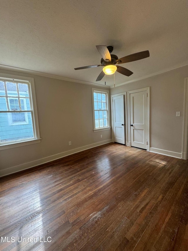 unfurnished room with ceiling fan, a textured ceiling, dark hardwood / wood-style flooring, and ornamental molding