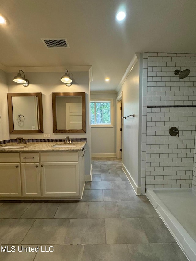 bathroom featuring tiled shower, crown molding, and vanity