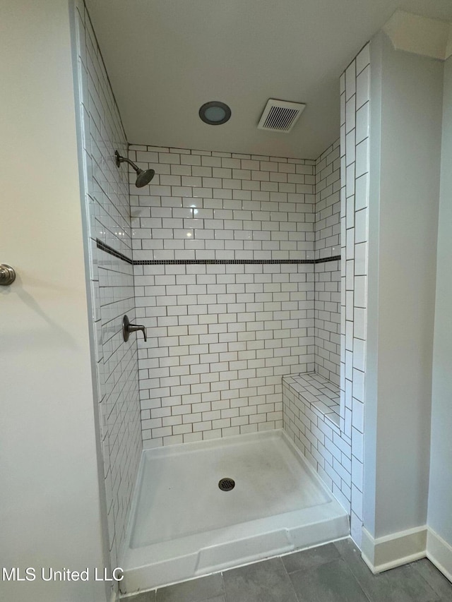 bathroom featuring tile patterned flooring and tiled shower