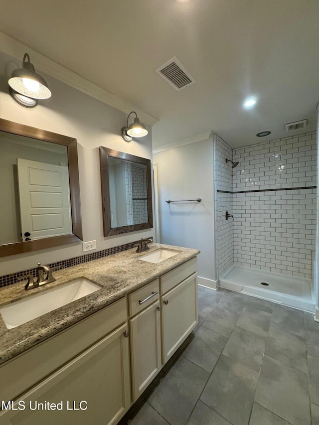 bathroom featuring tiled shower, vanity, tile patterned flooring, and ornamental molding