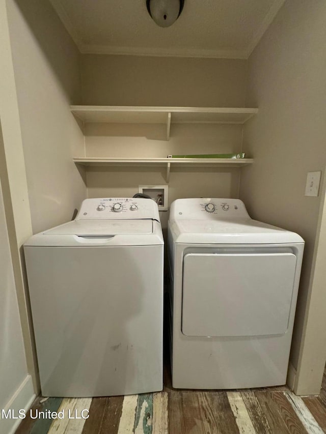 laundry room featuring hardwood / wood-style floors, washer and dryer, and crown molding