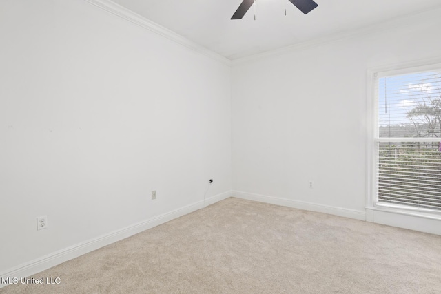 empty room featuring ornamental molding, light colored carpet, and ceiling fan