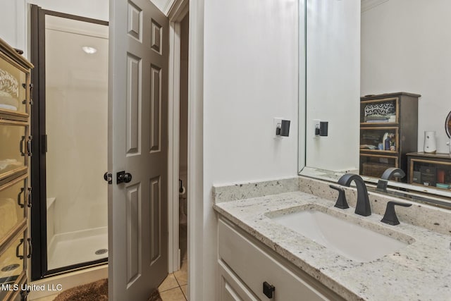 bathroom featuring vanity, tile patterned flooring, and walk in shower