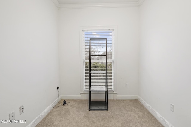 carpeted spare room featuring crown molding