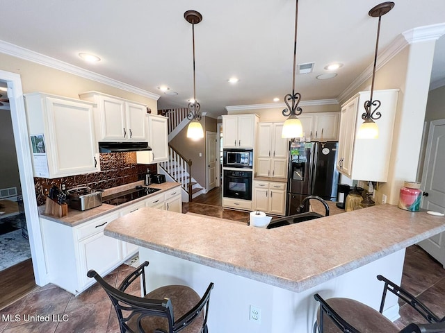 kitchen featuring crown molding, a peninsula, under cabinet range hood, visible vents, and black appliances