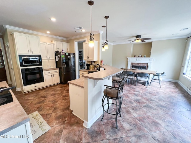 kitchen featuring ceiling fan, a kitchen breakfast bar, a peninsula, ornamental molding, and black appliances