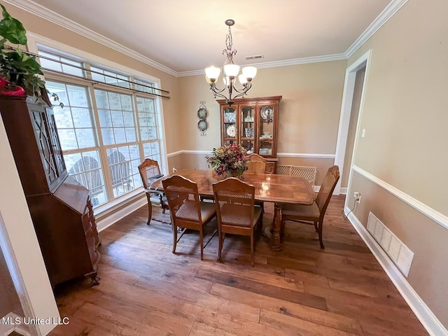 dining room featuring crown molding, wood finished floors, a chandelier, and visible vents
