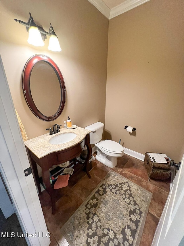 bathroom featuring vanity, ornamental molding, baseboards, and toilet