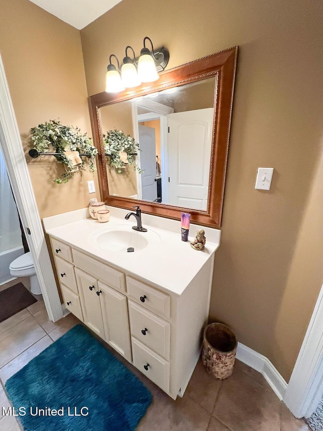 bathroom with toilet, tile patterned floors, and vanity