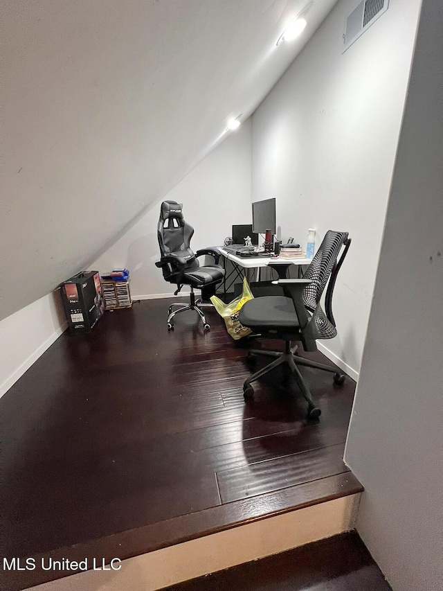 office featuring baseboards, visible vents, wood finished floors, and lofted ceiling