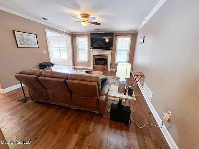 living area featuring ceiling fan, a fireplace, wood finished floors, and visible vents