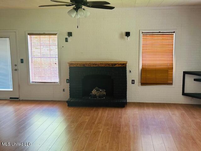 1561 Section Line Rd, Picayune, MS 39466 - unfurnished living room with wood finished floors, a ceiling fan, a fireplace, and crown molding