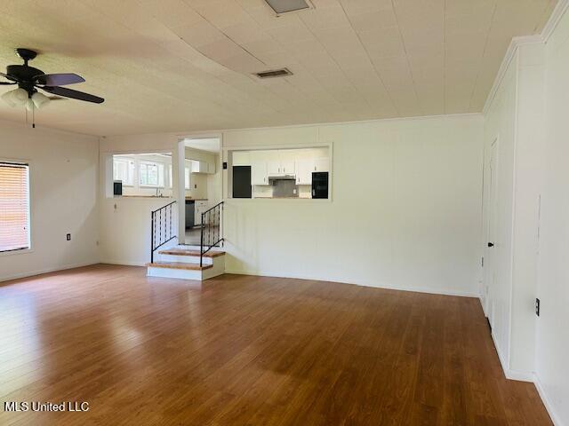 1561 Section Line Rd, Picayune, MS 39466 - unfurnished room featuring wood finished floors, ceiling fan, stairs, and baseboards
