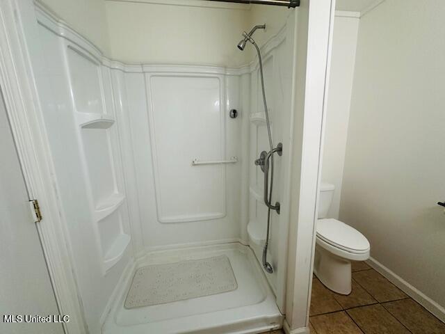 1561 Section Line Rd, Picayune, MS 39466 - bathroom with tile patterned floors, toilet, a stall shower, and baseboards