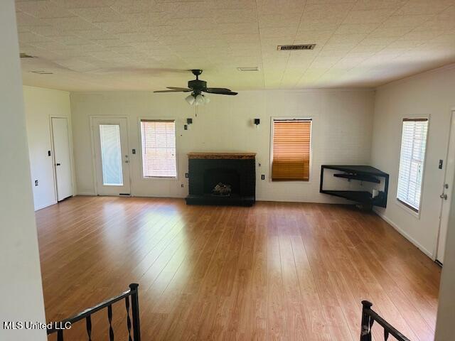 1561 Section Line Rd, Picayune, MS 39466 - unfurnished living room with wood finished floors, a ceiling fan, and a fireplace with raised hearth