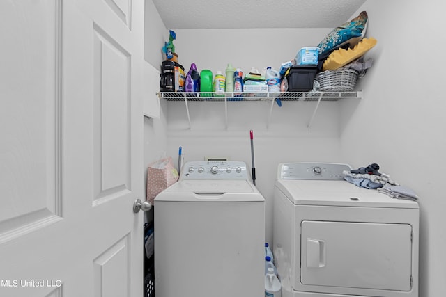 washroom with a textured ceiling and washer and clothes dryer