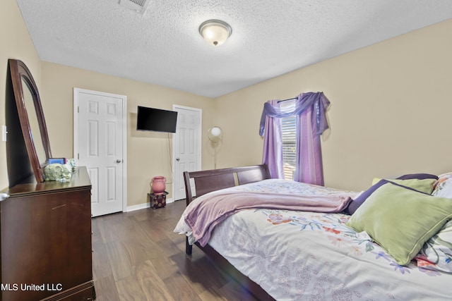 bedroom featuring visible vents, wood finished floors, and a textured ceiling
