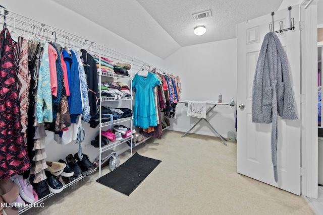 walk in closet with lofted ceiling and carpet floors