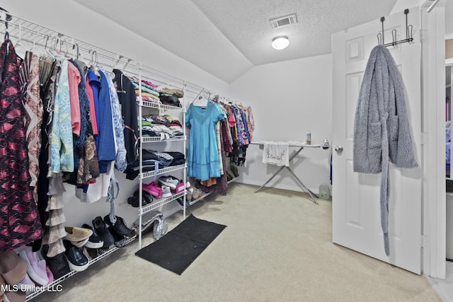 walk in closet featuring vaulted ceiling, visible vents, and carpet