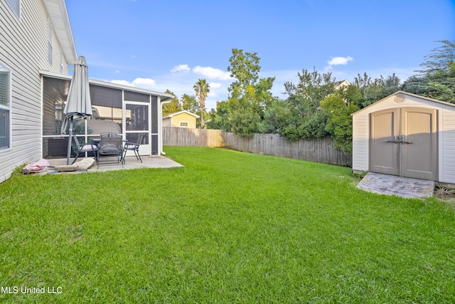 view of yard with a fenced backyard, an outbuilding, a patio, a sunroom, and a storage unit