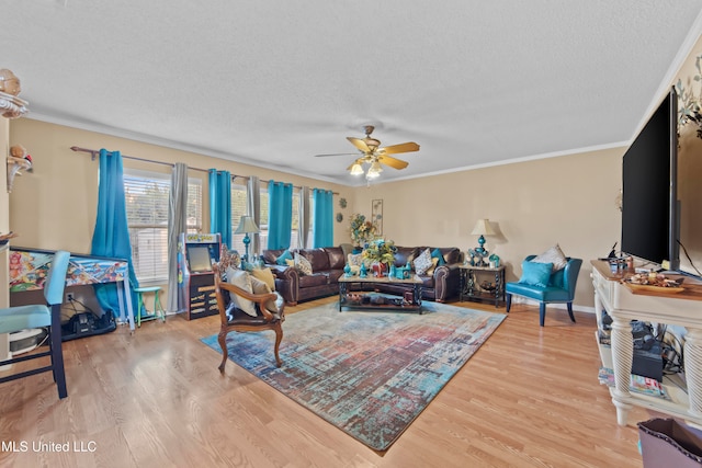 living room featuring ornamental molding, a textured ceiling, light wood-type flooring, and ceiling fan