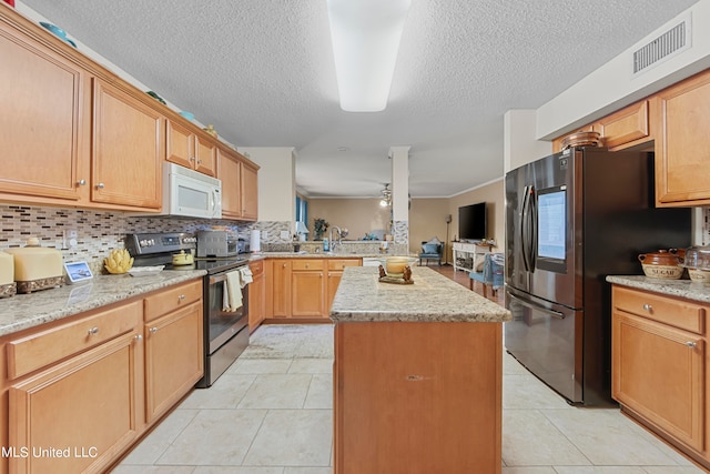 kitchen featuring tasteful backsplash, ceiling fan, appliances with stainless steel finishes, light tile patterned floors, and a center island