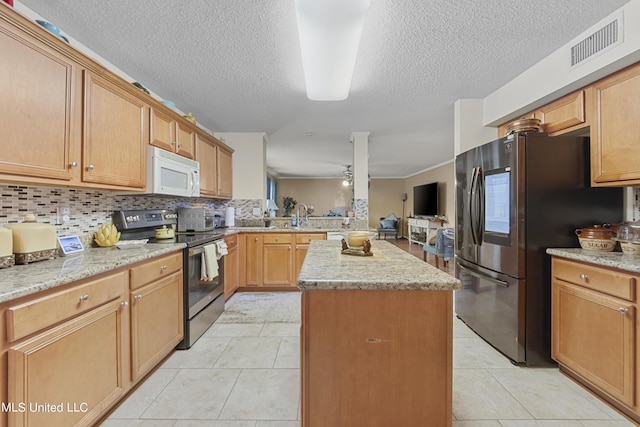 kitchen with stainless steel appliances, visible vents, a kitchen island, a peninsula, and a textured ceiling