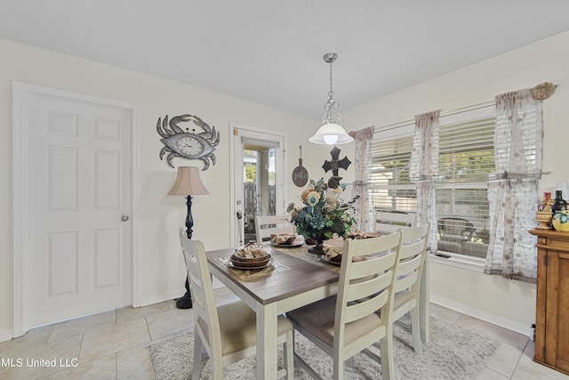 dining area with baseboards and light tile patterned flooring