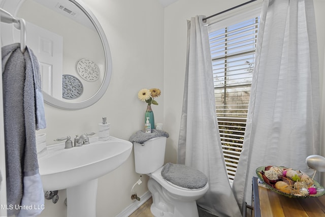 bathroom with visible vents, toilet, and baseboards