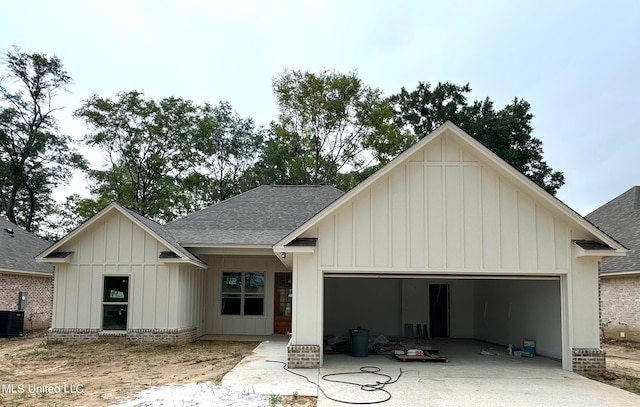 view of front facade featuring a garage and cooling unit