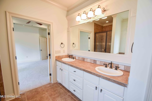 bathroom featuring vanity, crown molding, a shower with shower door, and tile patterned floors