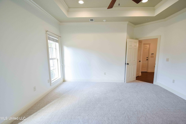 empty room featuring crown molding, a raised ceiling, and ceiling fan