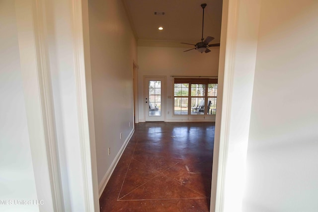 hallway with a high ceiling and dark tile patterned flooring