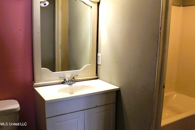 bathroom featuring a tub, vanity, and toilet