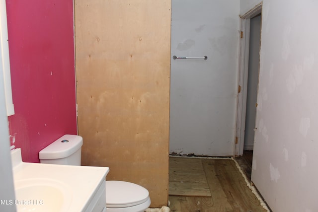 bathroom with wood-type flooring, vanity, and toilet