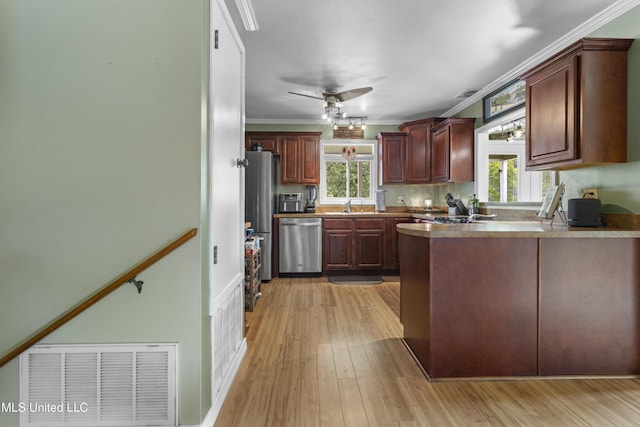4620 Holly Heath Dr, Gautier, MS 39553 - kitchen featuring appliances with stainless steel finishes, a peninsula, light wood-style flooring, a sink, and a ceiling fan
