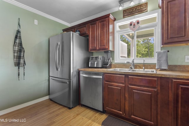 4620 Holly Heath Dr, Gautier, MS 39553 - kitchen with appliances with stainless steel finishes, a sink, ornamental molding, light wood-style floors, and baseboards