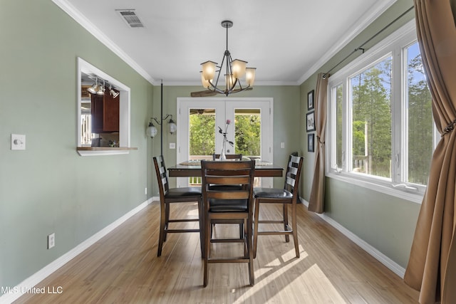 4620 Holly Heath Dr, Gautier, MS 39553 - dining room featuring plenty of natural light, a chandelier, wood finished floors, and crown molding