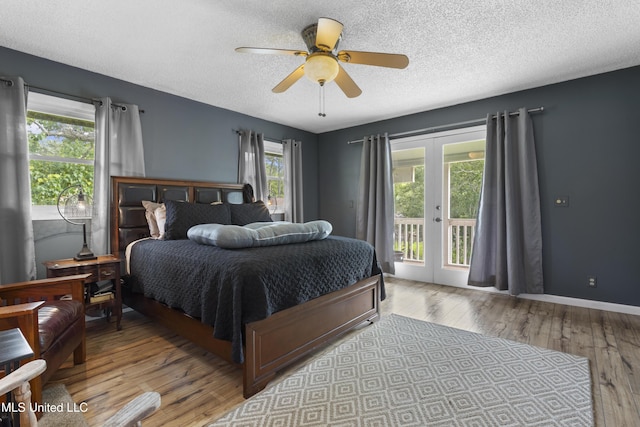 4620 Holly Heath Dr, Gautier, MS 39553 - bedroom featuring access to exterior, hardwood / wood-style flooring, a textured ceiling, french doors, and a ceiling fan