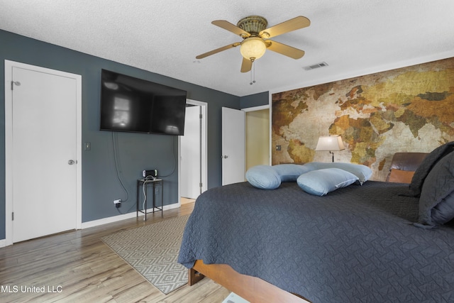 4620 Holly Heath Dr, Gautier, MS 39553 - bedroom with wood finished floors, ceiling fan, baseboards, and an accent wall