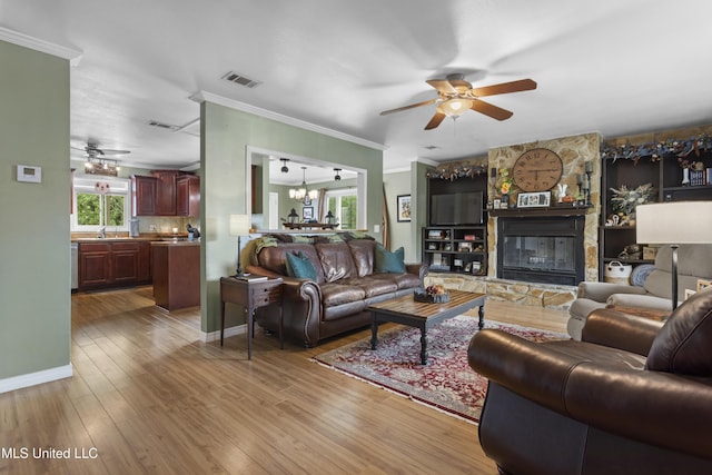 4620 Holly Heath Dr, Gautier, MS 39553 - living area featuring ceiling fan, ornamental molding, wood finished floors, and a stone fireplace