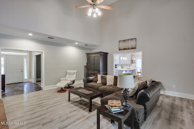 138 Oak Ridge Cir, Madison, MS 39110 - living room featuring light wood finished floors, a high ceiling, baseboards, and a ceiling fan