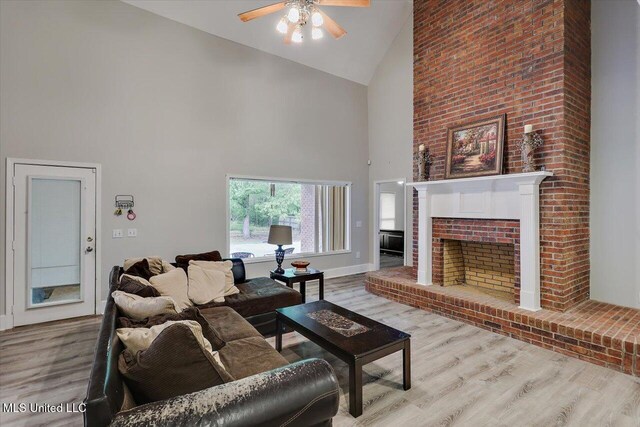 138 Oak Ridge Cir, Madison, MS 39110 - living room with high vaulted ceiling, a ceiling fan, wood finished floors, a brick fireplace, and baseboards