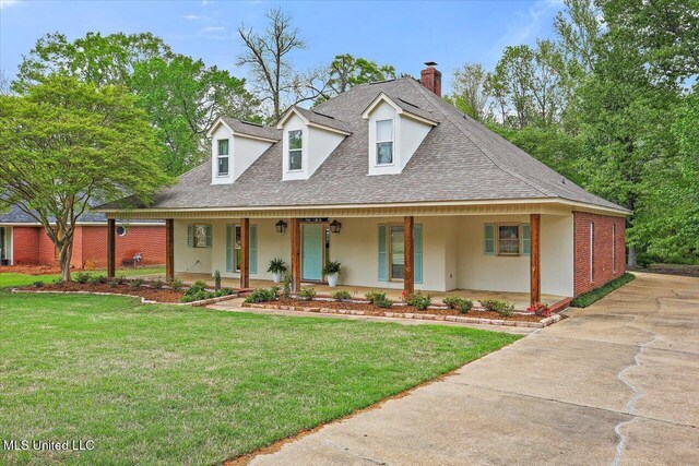 138 Oak Ridge Cir, Madison, MS 39110 - view of front facade featuring roof with shingles, a chimney, covered porch, a front yard, and stucco siding